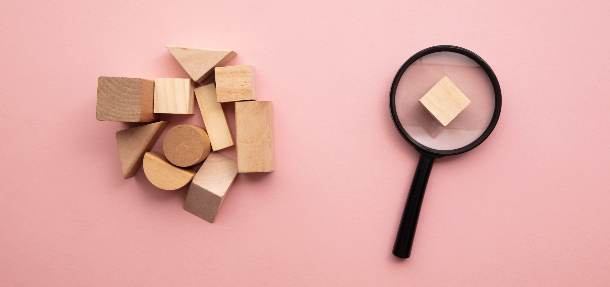 Wooden block placed on a magnifying glass showing close examination of details