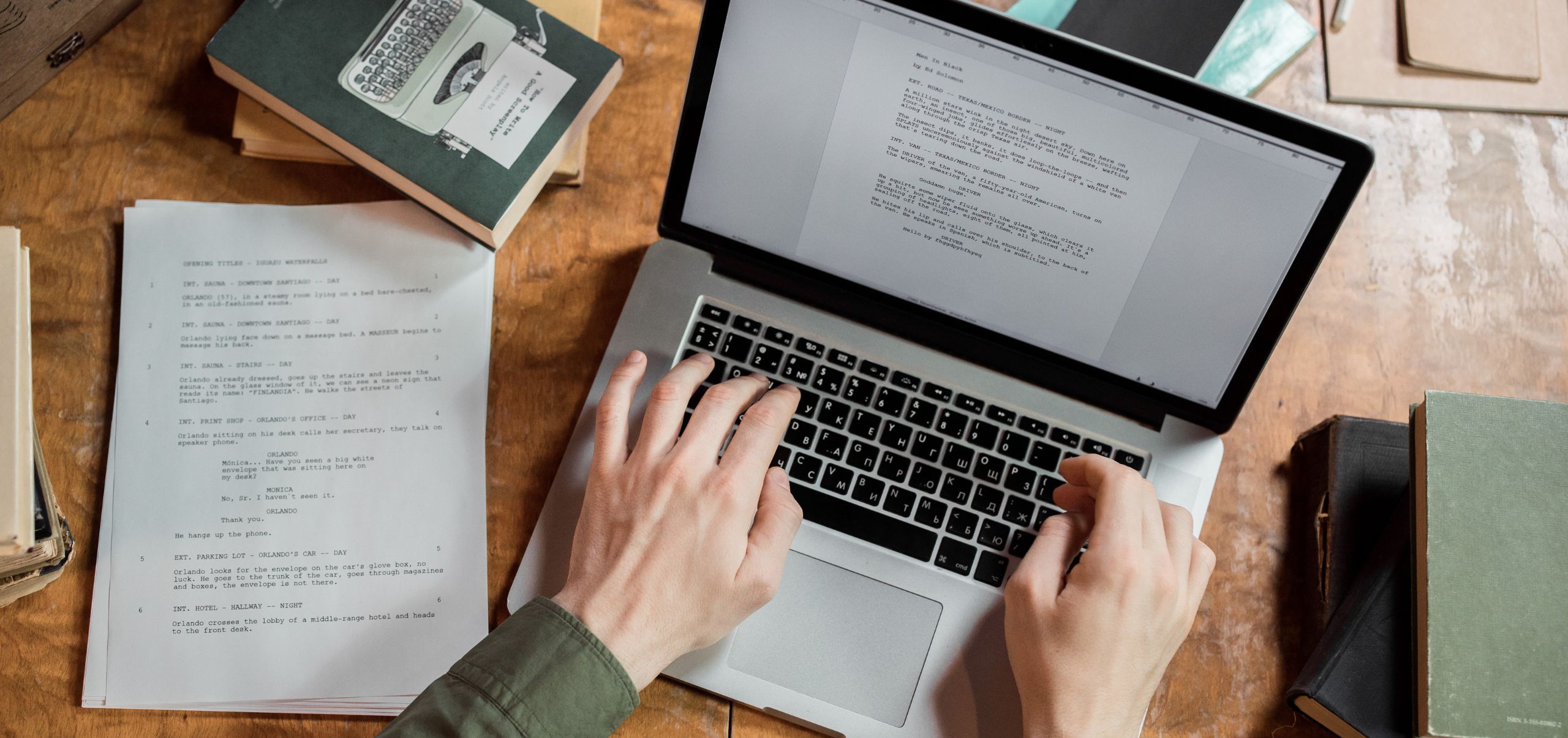 Person using a laptop to write notes from a paper on the side, demonstrating organized work