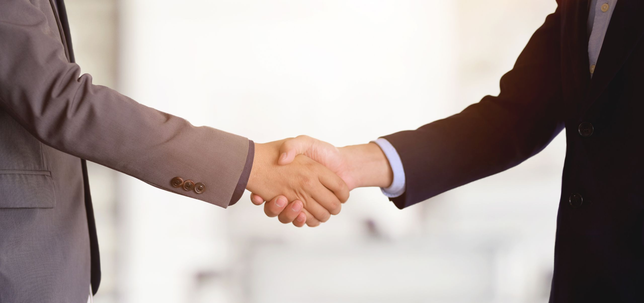 Two people shaking hands, symbolizing trust and credibility in successful brand relationships
