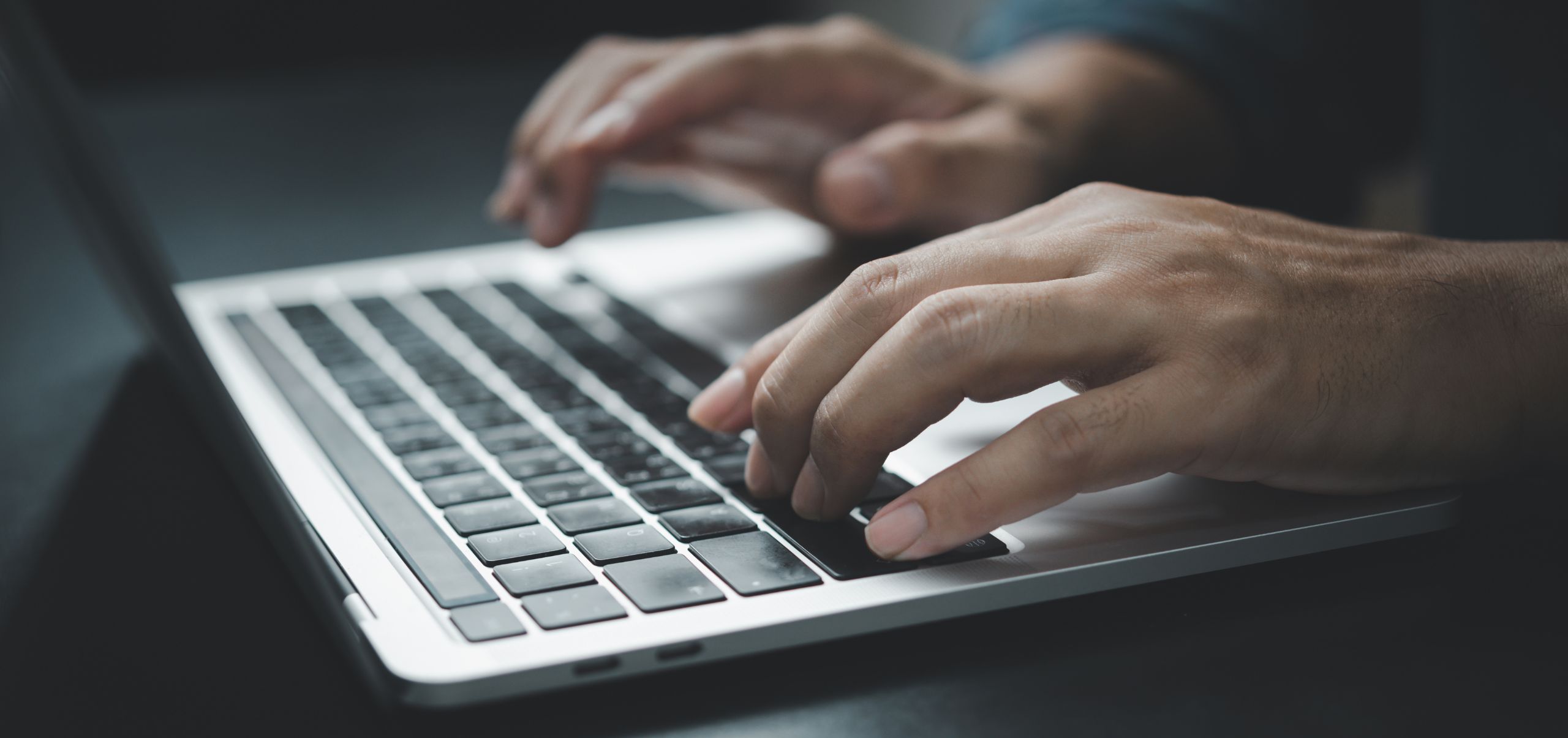 Person typing on a laptop to craft effective email subject lines