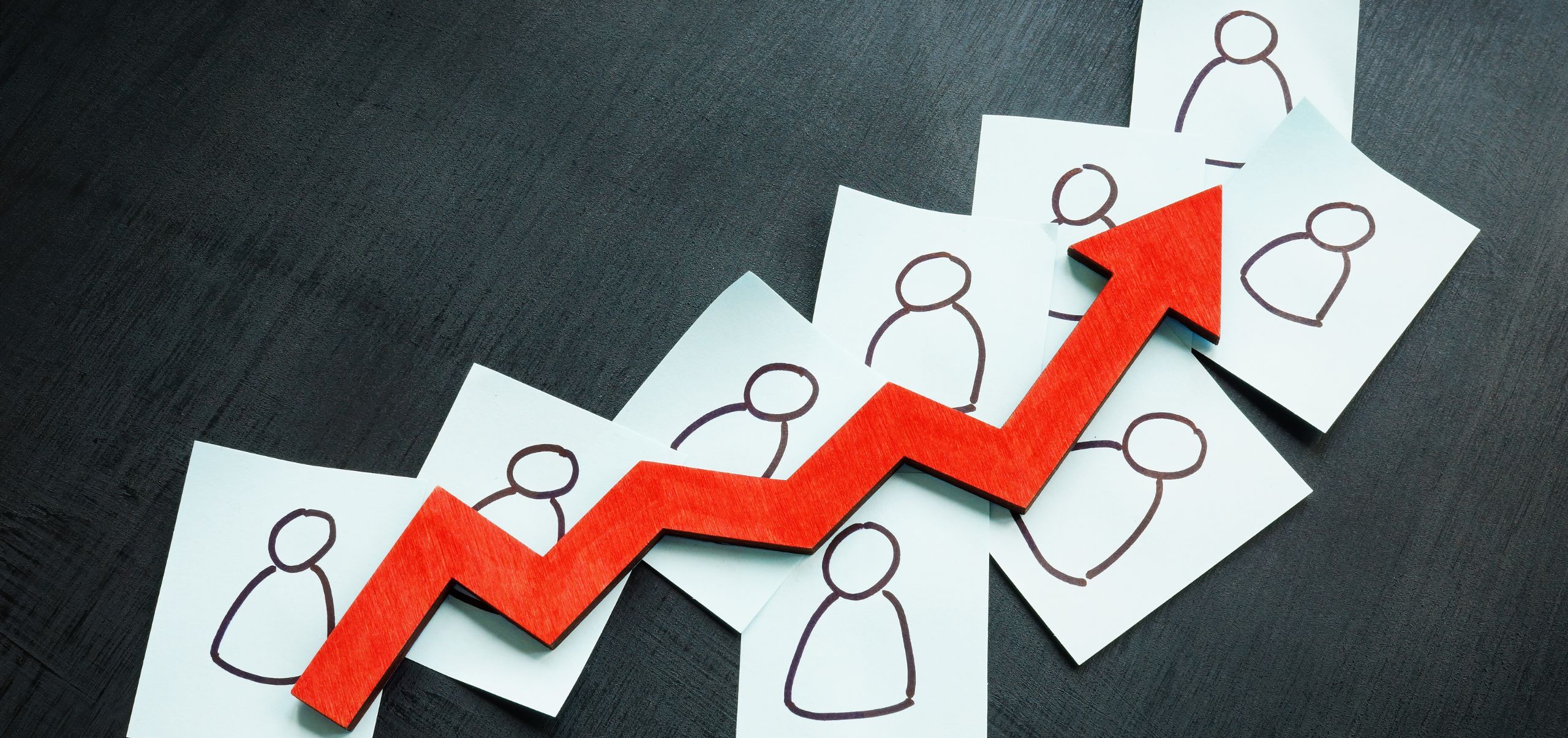 Papers with customer icons and a red trend line showing growth in customer loyalty