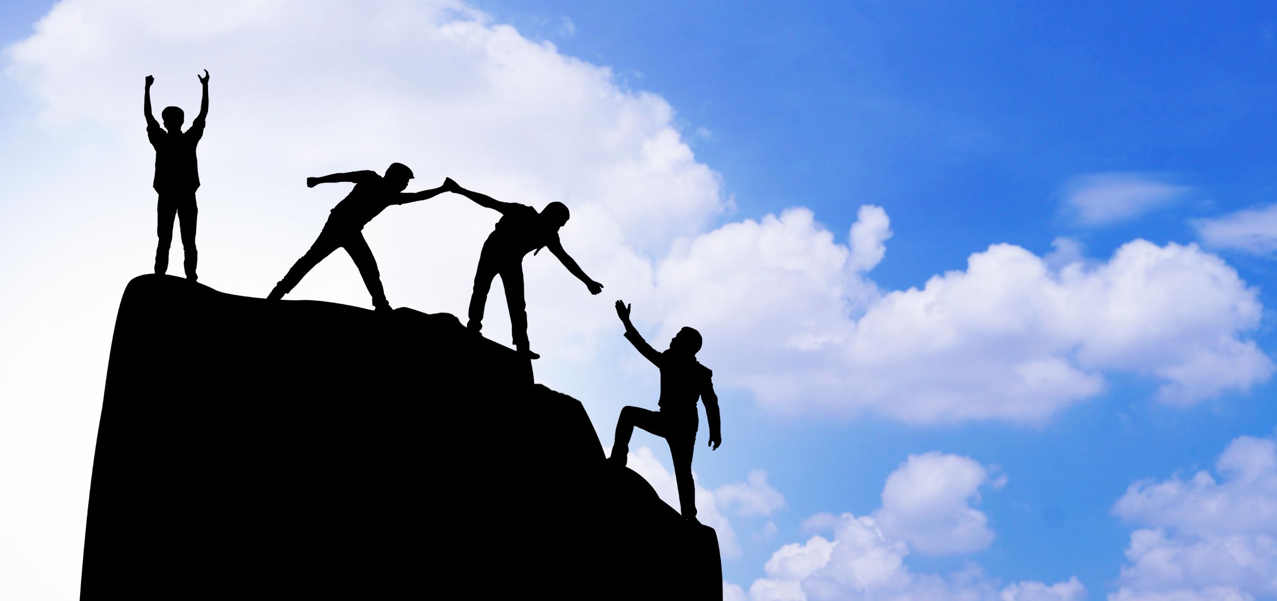 Colleagues helping each other climb toward success, symbolizing mentorship and teamwork in management