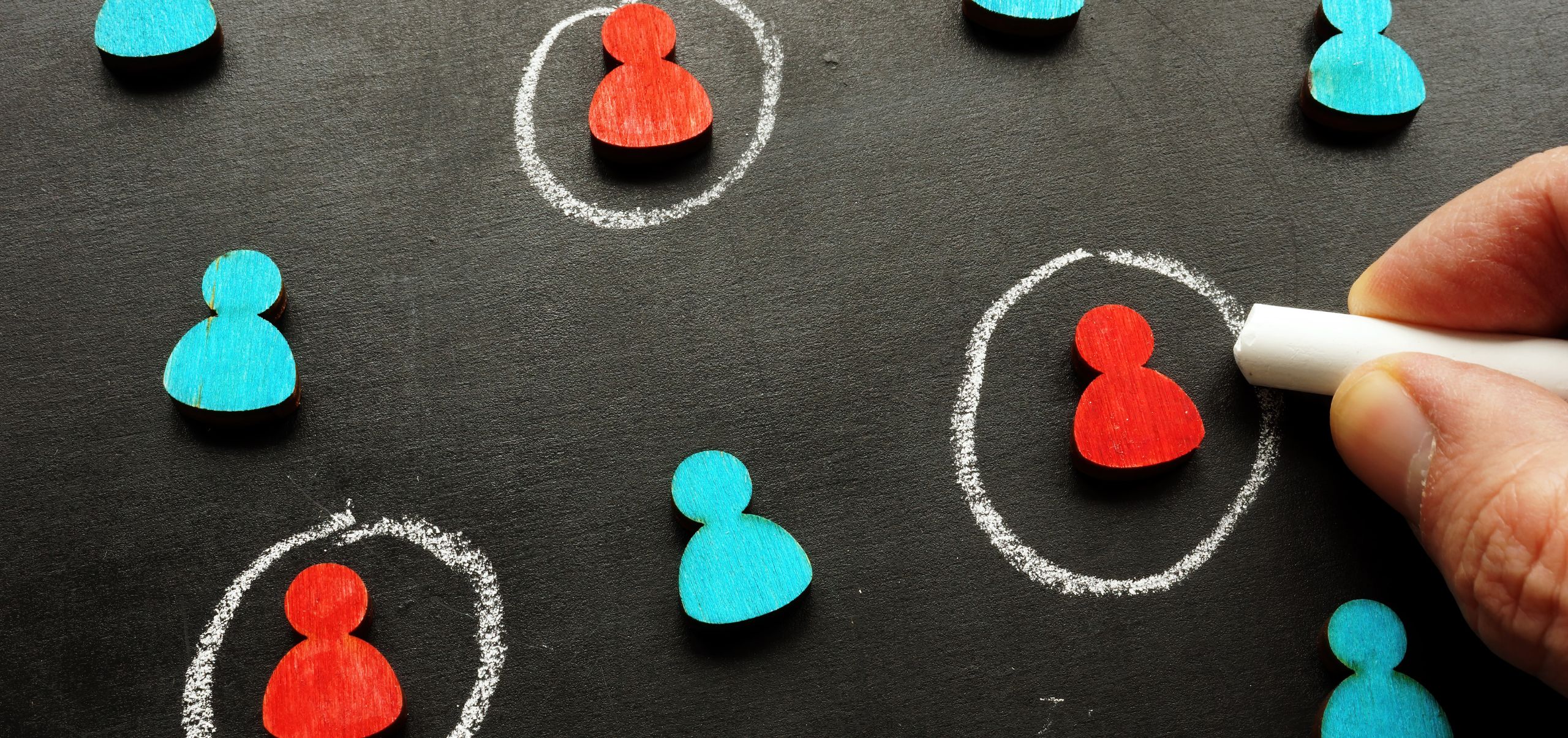 Red and blue figures with some circled in chalk to represent a target audience in market research