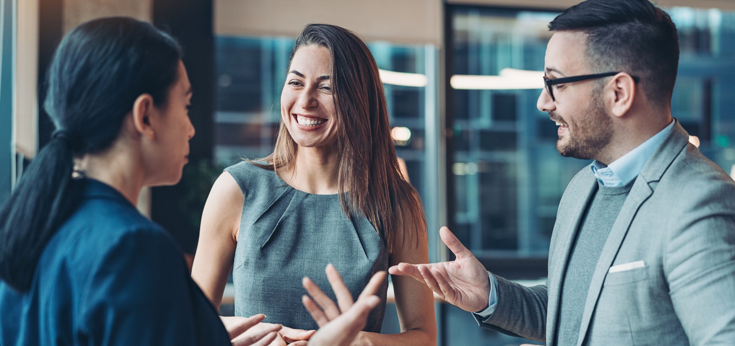 One male and two female figures communicating, representing developing networking skills for professional growth