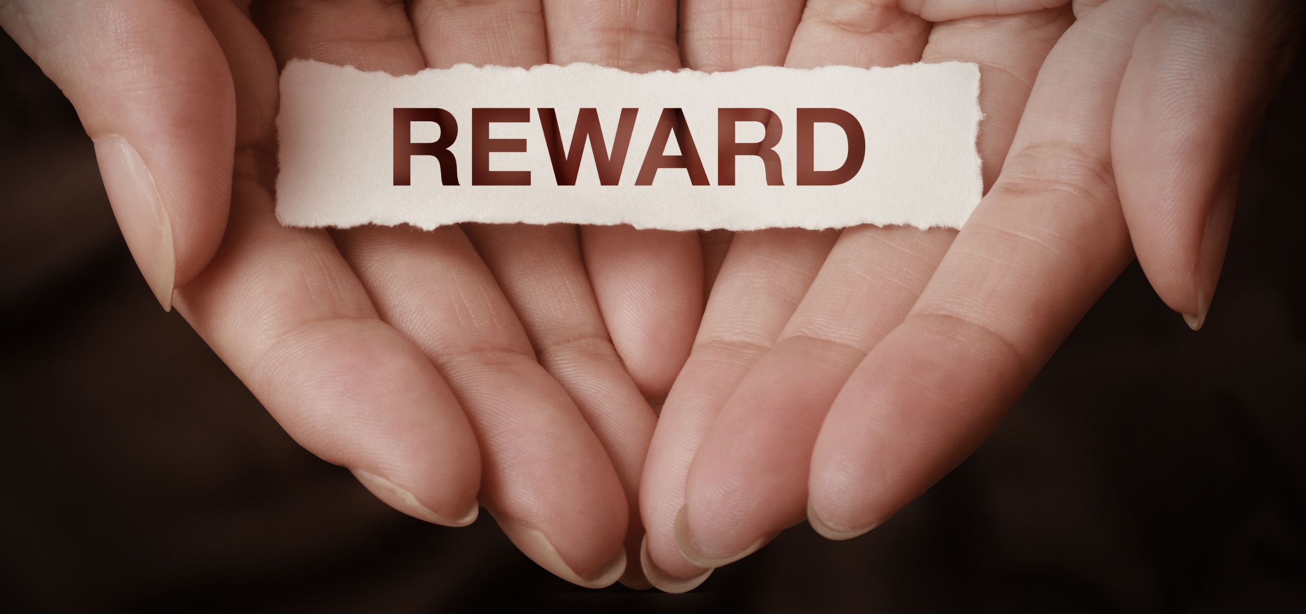 Person holding a paper with reward written on it to highlight loyalty programs