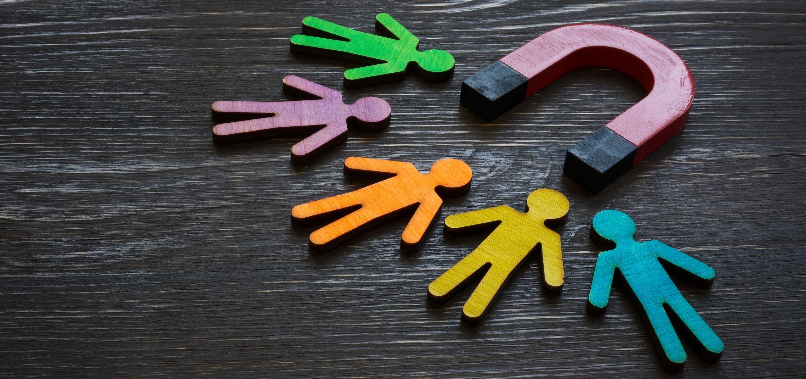 Magnet attracting five colorful customer icons to represent customer loyalty