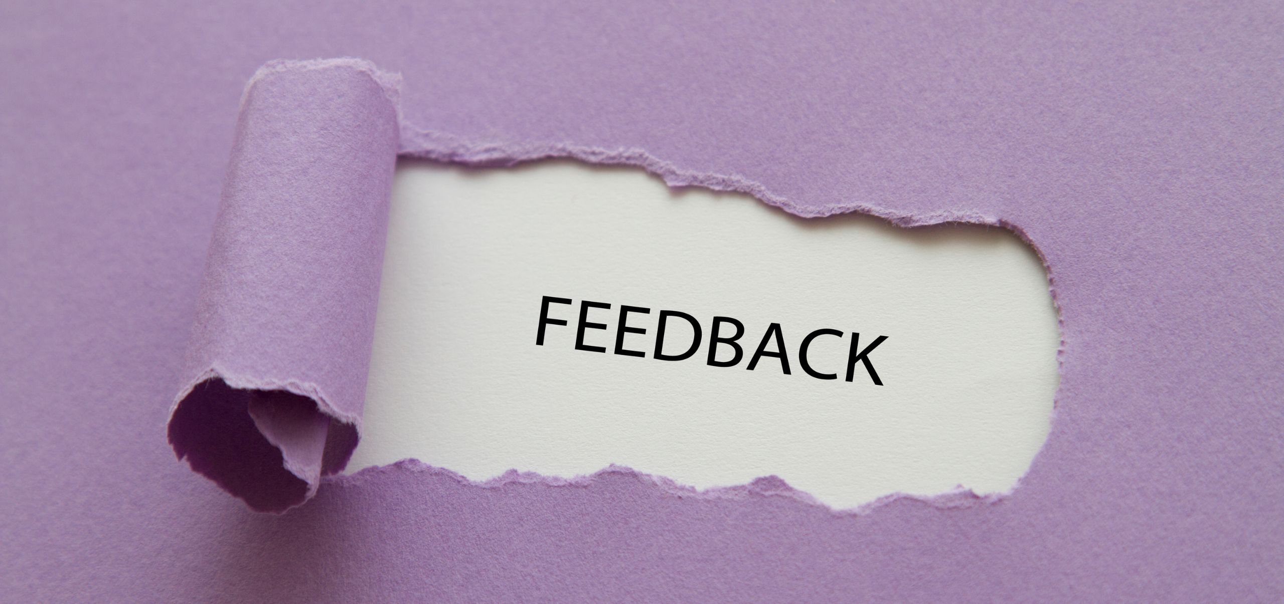 A torn purple sheet revealing the word “Feedback,” representing giving constructive feedback in leadership